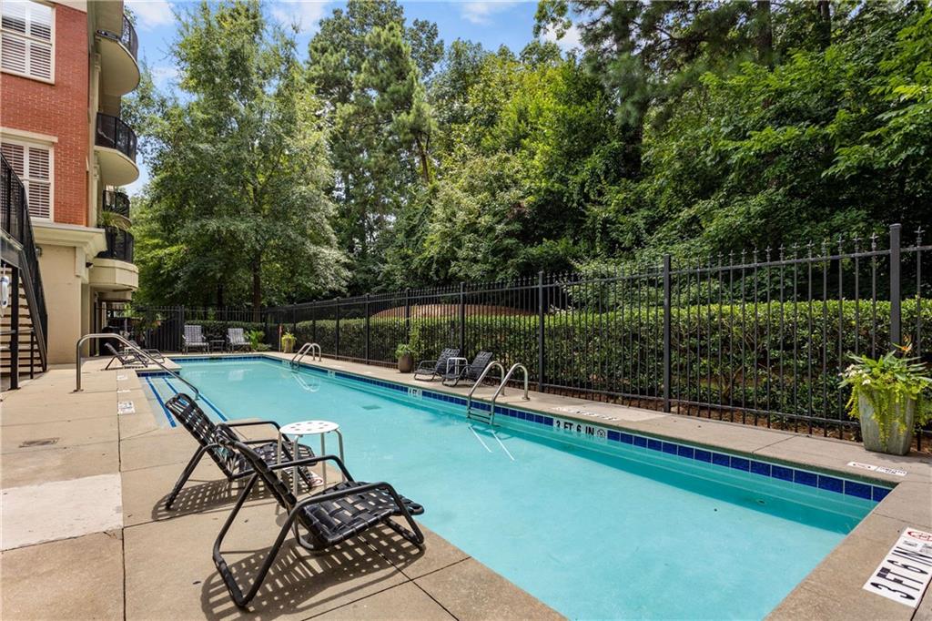 560 Dutch Valley Road Northeast, Unit 311 Atlanta, GA 30324 - Photo 36 of 44 a view of a swimming pool with a patio and garden