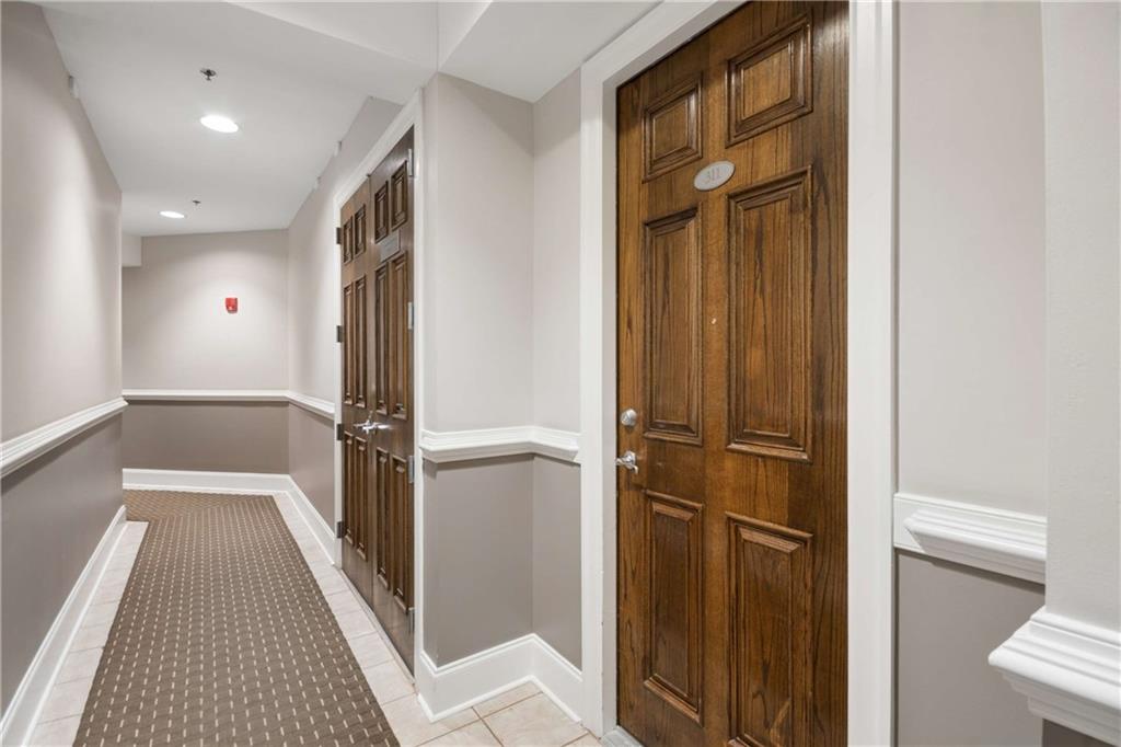 560 Dutch Valley Road Northeast, Unit 311 Atlanta, GA 30324 - Photo 4 of 44 a view of a hallway with a refrigerator and wooden floor