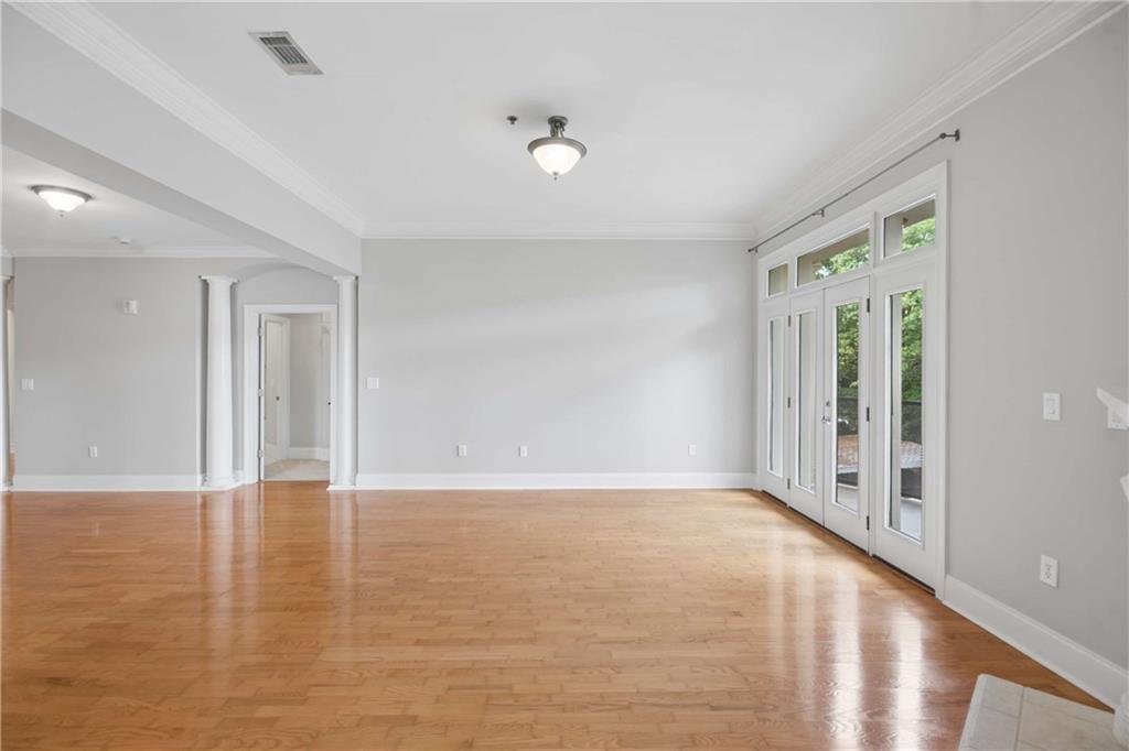560 Dutch Valley Road Northeast, Unit 311 Atlanta, GA 30324 - Photo 10 of 44 a view of an empty room with wooden floor and a window