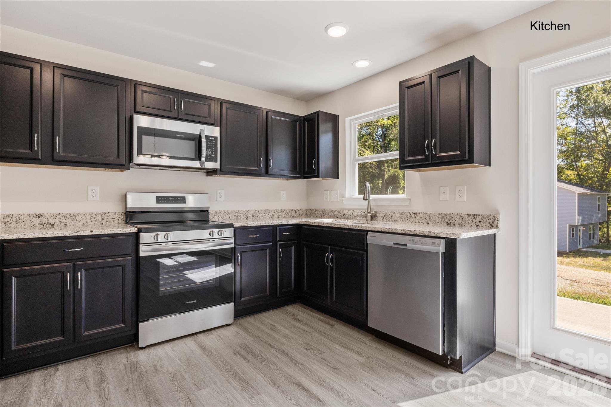 2315 State Rd S-29-395 Lancaster, SC 29720 - Photo 3 of 21 a kitchen with stainless steel appliances granite countertop wooden cabinets and a stove top oven