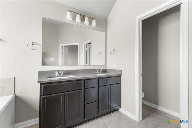 a bathroom with a double vanity sink and mirror