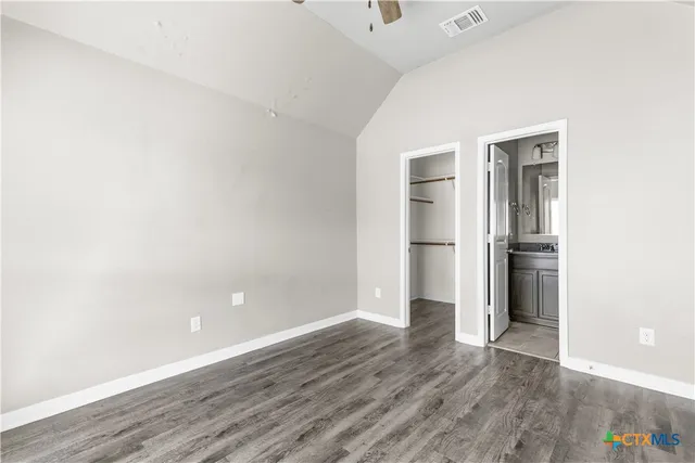 an empty room with wooden floor and entrance