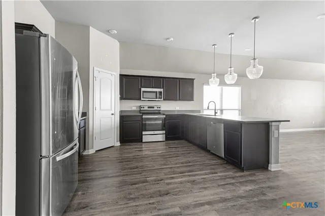 a kitchen with kitchen island a counter space stainless steel appliances and cabinets