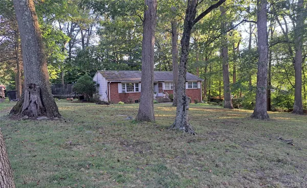 a view of a house with a backyard and trees
