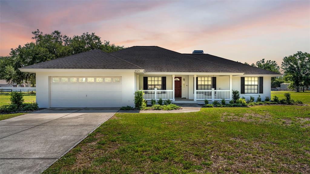 8525 North Campbell Road Lakeland, FL 33810 - Photo 2 of 45 a front view of a house with a yard and garage