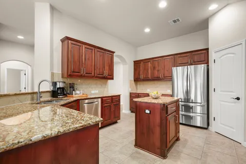 a kitchen with stainless steel appliances granite countertop a stove refrigerator sink and cabinets