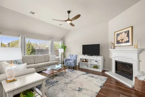 a living room with furniture a flat screen tv and a fireplace