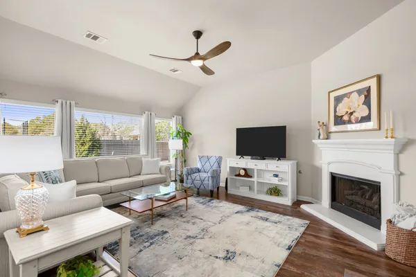 a living room with furniture a flat screen tv and a fireplace