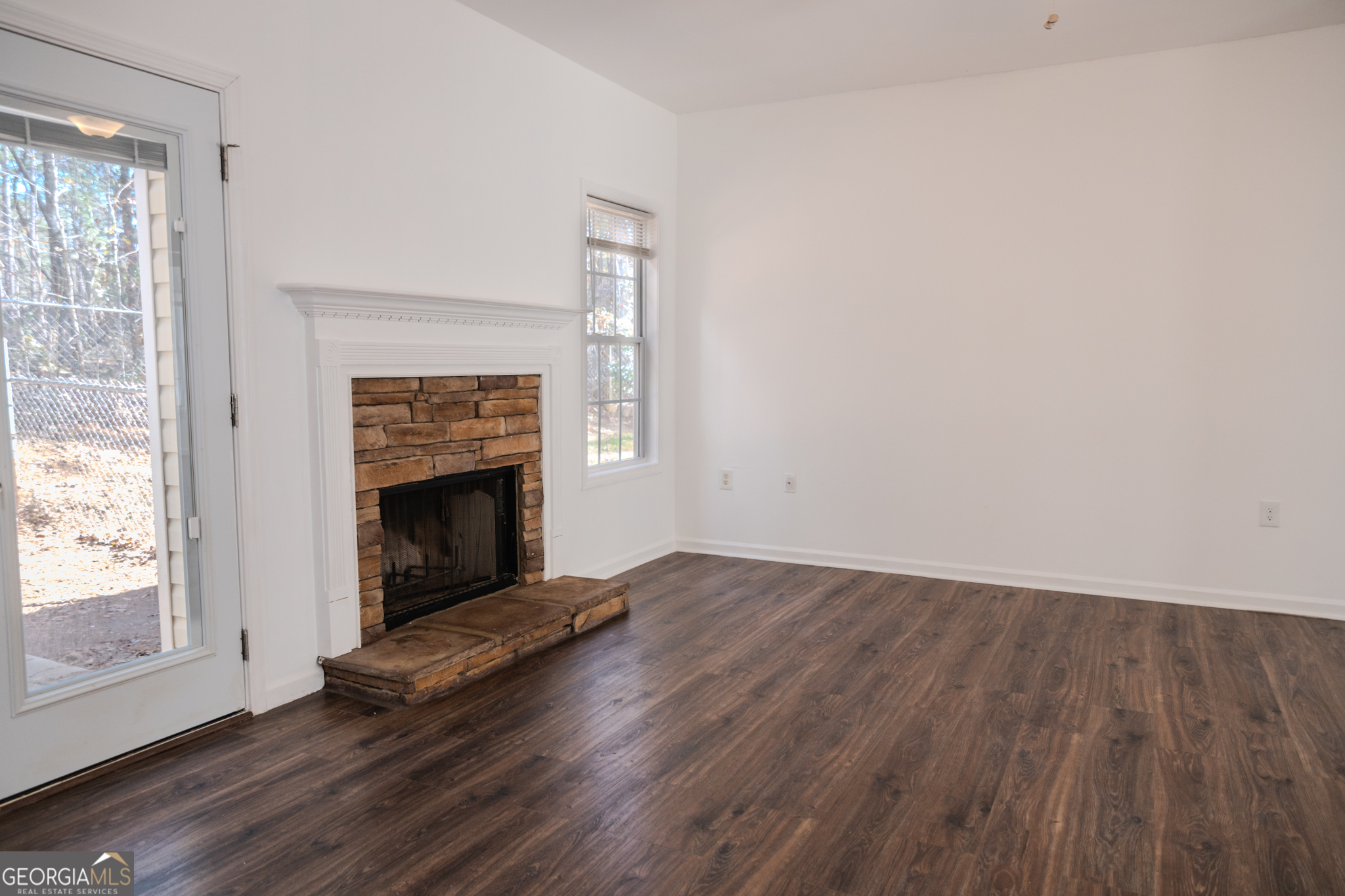55 Corn Row Court Newnan, GA 30263 - Photo 11 of 72 an empty room with wooden floor fireplace and windows