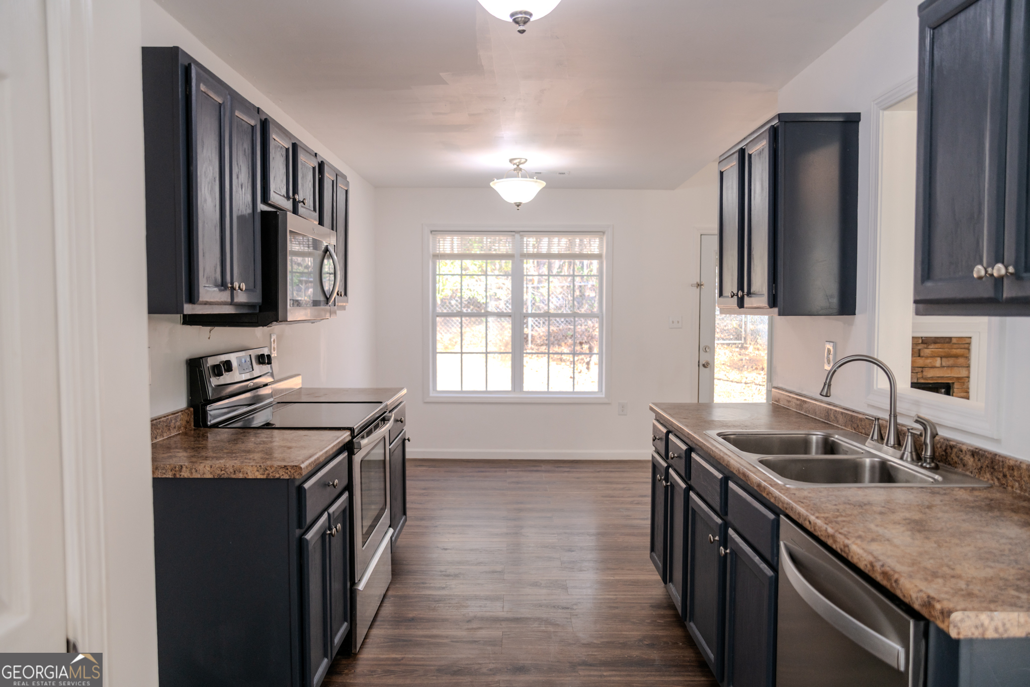 55 Corn Row Court Newnan, GA 30263 - Photo 23 of 72 a kitchen with stainless steel appliances granite countertop a sink stove and cabinets