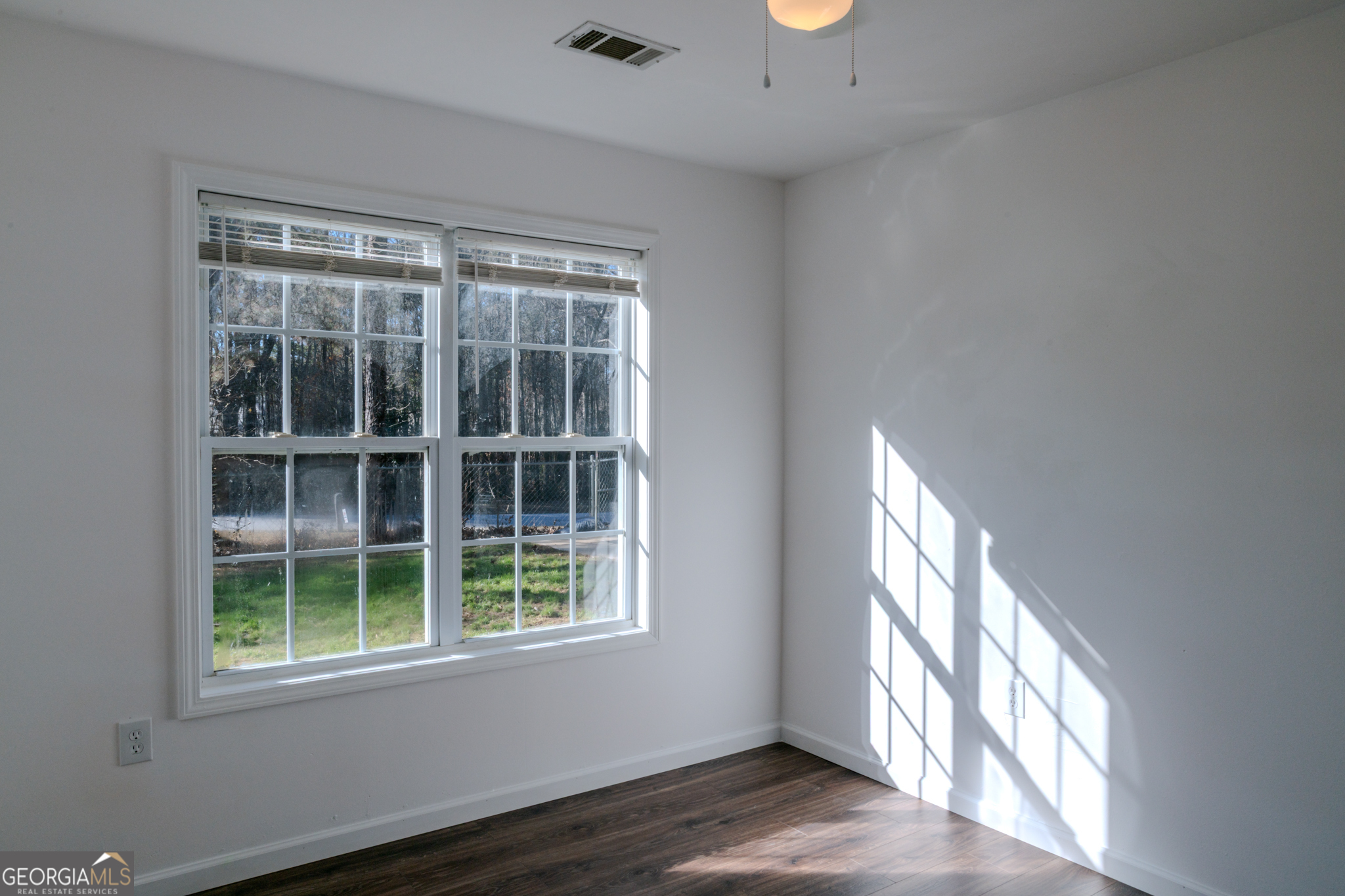 55 Corn Row Court Newnan, GA 30263 - Photo 36 of 72 a view of an empty room with wooden floor and a window