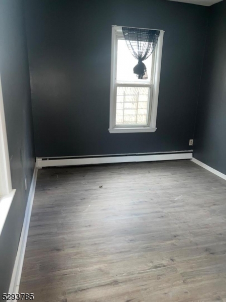 32 Rosehill Place, Unit 1 Irvington, NJ 07111 - Photo 8 of 9 an empty room with wooden floor and windows