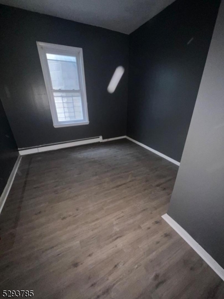 32 Rosehill Place, Unit 1 Irvington, NJ 07111 - Photo 9 of 9 an empty room with wooden floor and windows