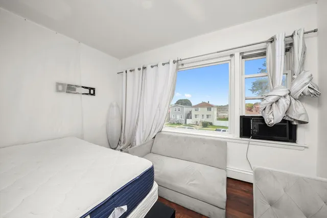 a bedroom with a bed dresser and a window