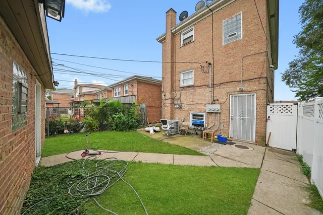 a view of a backyard with table and chairs under an umbrella