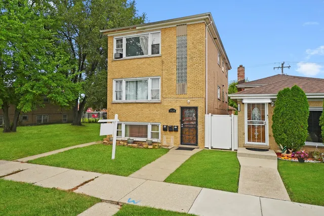 an aerial view of residential houses with outdoor space and parking