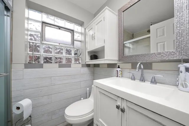 a bathroom with a toilet a sink and mirror