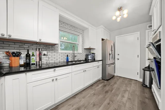 a kitchen with stainless steel appliances sink refrigerator and window