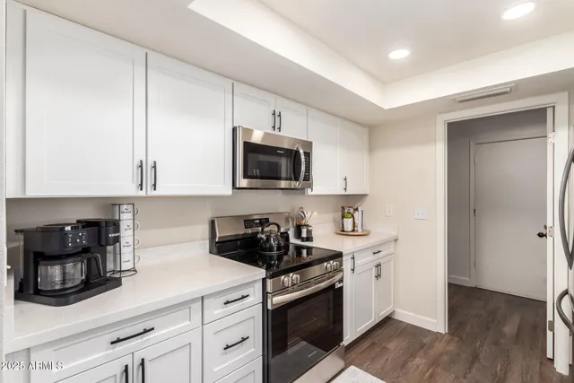 a kitchen with stainless steel appliances a sink stove top oven and refrigerator