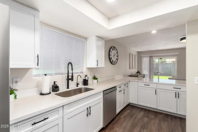 a kitchen with stainless steel appliances granite countertop a sink a stove a microwave and wooden cabinets