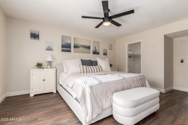 a spacious bedroom with a bed and wooden floor