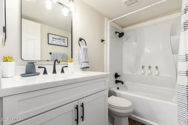 a bedroom with a large bed and a chandelier fan