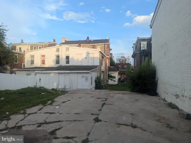 a view of house with yard and car parked