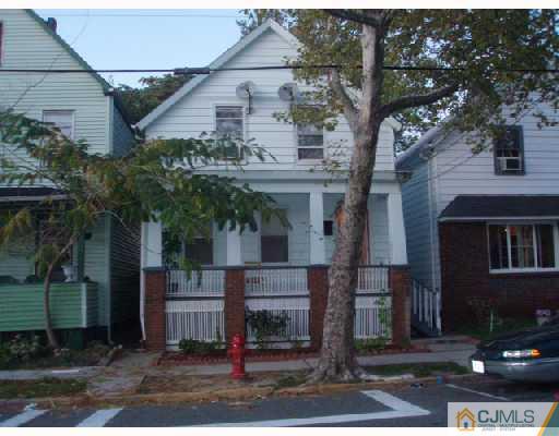 a front view of a house with a tree