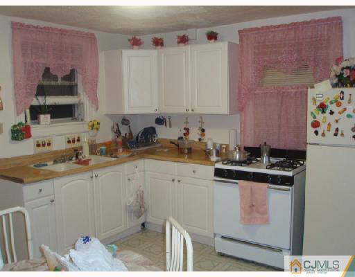 168 Lynd Street Perth Amboy, NJ 08861 - Photo 4 of 8 a kitchen with a sink stove and cabinets