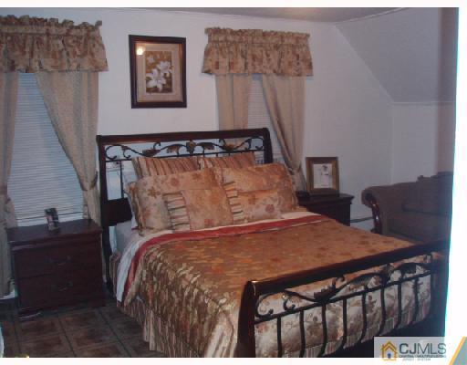 168 Lynd Street Perth Amboy, NJ 08861 - Photo 6 of 8 a bed sitting in a bedroom next to a window