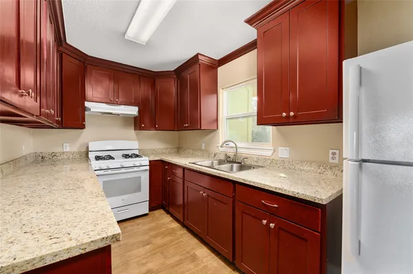 a kitchen with stainless steel appliances granite countertop a sink stove and refrigerator