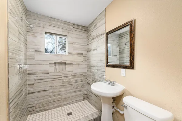 a bathroom with a sink and mirror with toilet