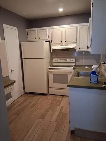 a kitchen with a refrigerator sink and cabinets