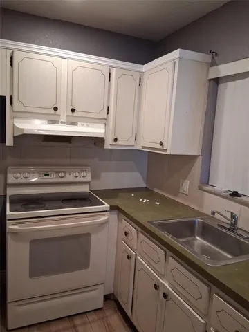 a kitchen with granite countertop white cabinets and white appliances