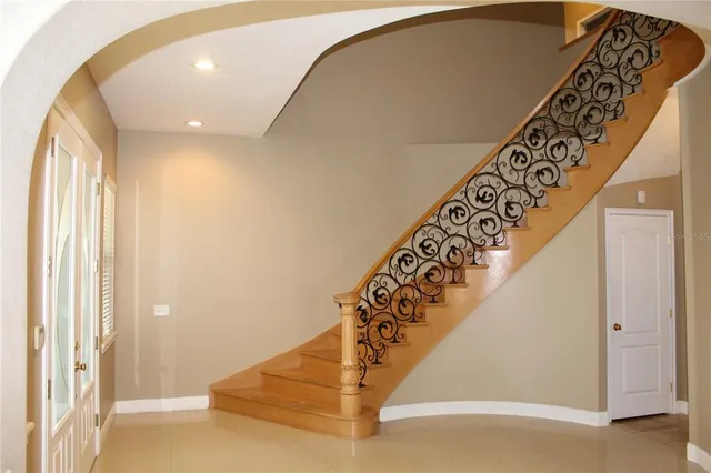 an empty room with a chandelier fan and windows