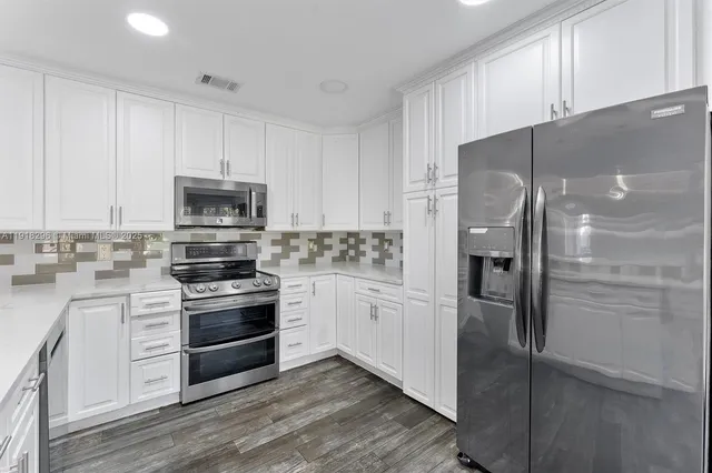a kitchen with stainless steel appliances a refrigerator sink and cabinets
