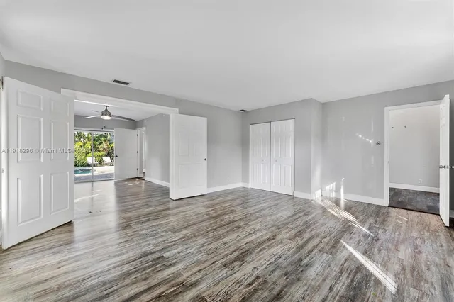 a view of empty room with wooden floor and window