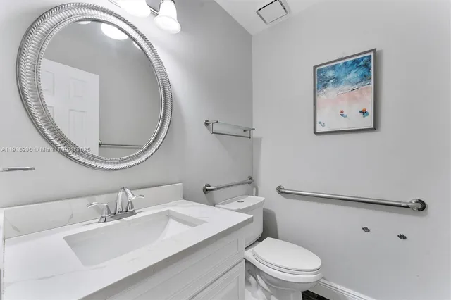 a bathroom with a toilet a sink and a mirror