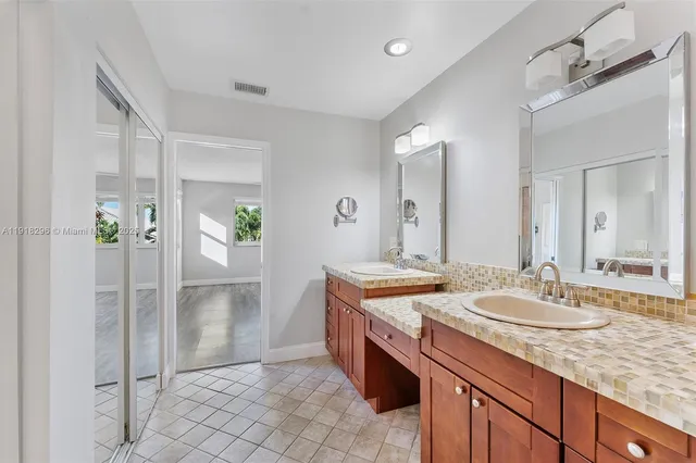 a spacious bathroom with a granite countertop sink and a mirror