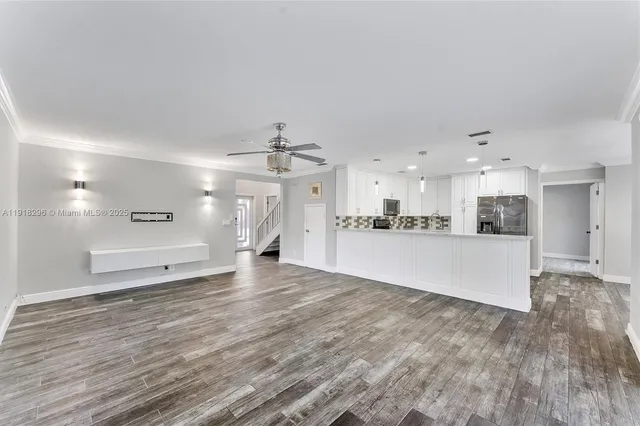 a view of an empty room and kitchen view