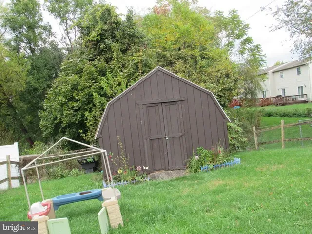 a view of a backyard with potted plants and large tree