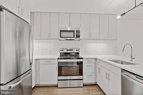 a kitchen with white cabinets and stainless steel appliances