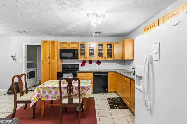 a kitchen with stainless steel appliances granite countertop a stove and a dining table chair