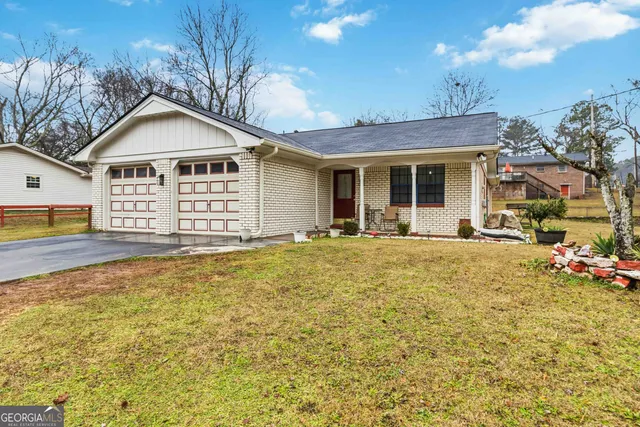 a front view of a house with a large garden