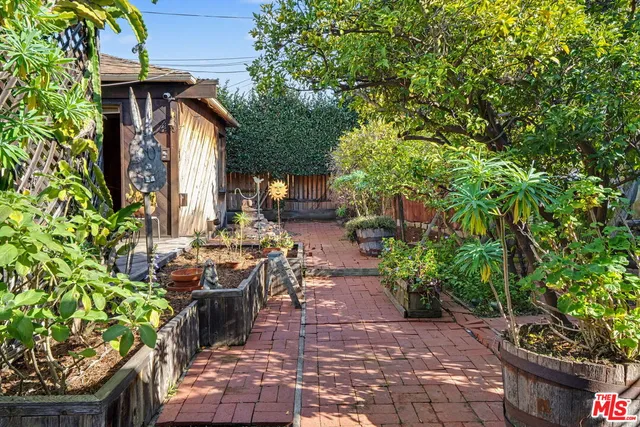 a view of a patio with table and chairs potted plants and large tree