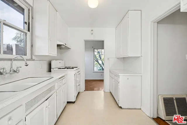 a kitchen with granite countertop white cabinets and white appliances