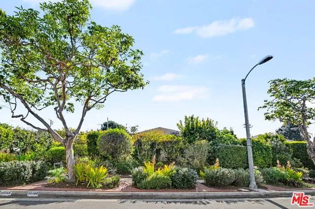 an aerial view of a house with garden space and street view