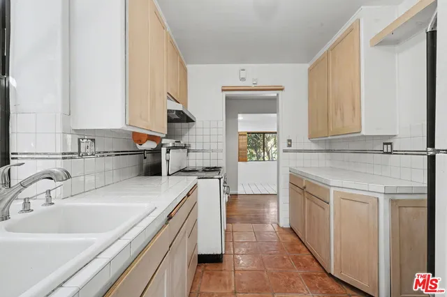a kitchen with a sink and a stove top oven