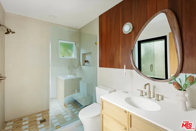 a bathroom with a toilet sink and mirror