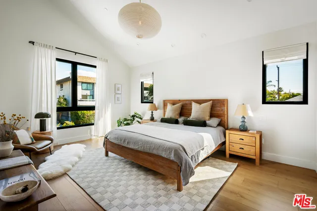 a spacious bedroom with a bed and glass windows